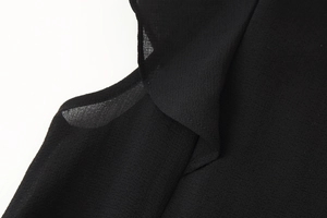 Close-up of black ruffled chiffon fabric layers with detailed weave and stitching