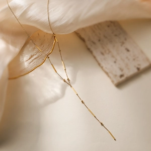 Minimalist 18K gold plated stainless steel necklace with bar and bead charm on silk