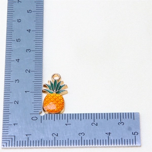 Macro shot of a pineapple alloy charm with yellow enamel showing 2.5cm height dimension