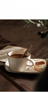 Detailed close-up of a Japanese ceramic coffee cup set with oval tray on wooden table