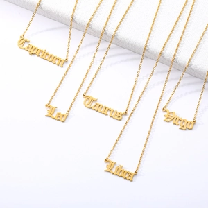 Golden stainless steel zodiac necklaces with old English font pendants on white background