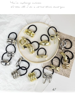 Macro shot of assorted gold and silver alloy hair ties with minimalist geometric ornaments