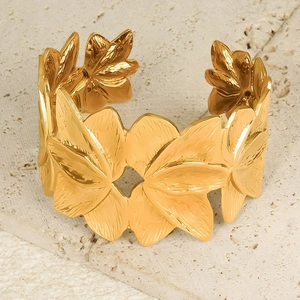 Eleganter 18K vergoldeter Edelstahl-Armreif mit Blütenrelief auf steinernem Hintergrund