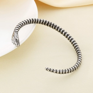 Detailed view of the vintage snake head bracelet with silver scale texture and oxidized finish
