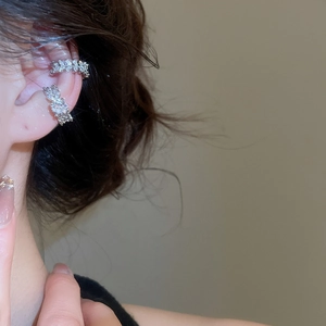 Macro shot of silver zircon bow ear cuffs on model showing sparkling metal details