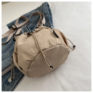 Detail der beigen Nylon-Beuteltasche mit seitlichen Netzeinsätzen und Schultergurt