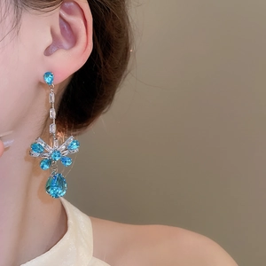 Detail of drop earrings with blue water-drop and flower-shaped cubic zirconia stones