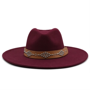 Detail of burgundy wool fedora featuring a brown leather band with silver metal studs