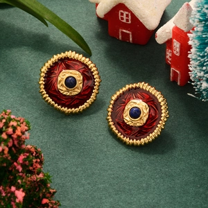 Macro detail of vintage Christmas flower earrings with red enamel and blue gemstone