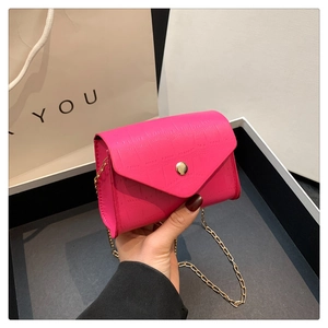 Detailed front view of a pink crocodile pattern crossbody bag with a gold chain strap