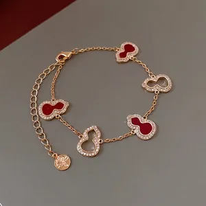 Elegant gold bracelet featuring red and hollow zircon wulu charms in a chic Chinese style
