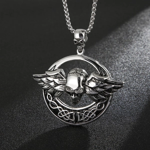 Detailed macro shot of vintage silver skull pendant with angel wings and Celtic knotwork