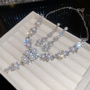 Elegant floral pearl necklace and earring set displayed in a premium velvet gift box