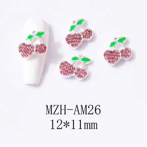 Detail view of 3D cherry nail art charms with pink rhinestones and green enamel leaf