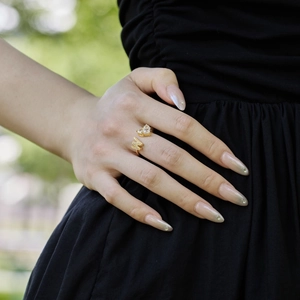 Close-up of golden letter W and M ring with cubic zirconia worn on female finger