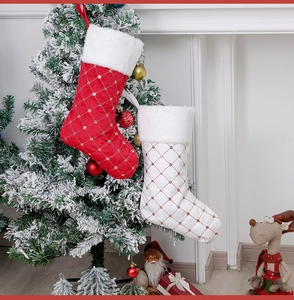 Quilted red and white Christmas stockings with faux fur trim hanging on tree