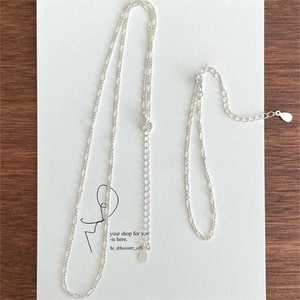 Detailed macro view of S925 sterling silver Figaro chain bracelet and necklace set