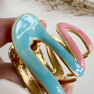 Elegante pinza per capelli in metallo dorato con onde in smalto azzurro e rosa