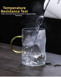 Heat-resistant glass tea mug with gold handle undergoing extreme thermal shock test