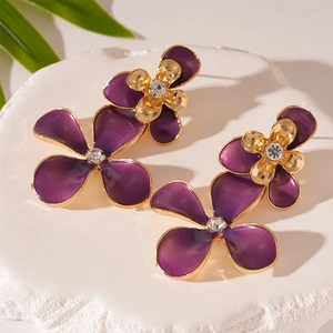 Macro detail of purple flower earrings with gold plating and a sparkling center zircon