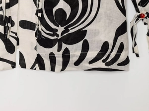 Detail of floral print fabric with red bead accents and high-quality hem stitching