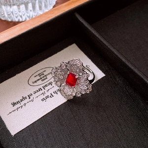 Close-up of a floral ring featuring a red rectangular stone and zircon petals
