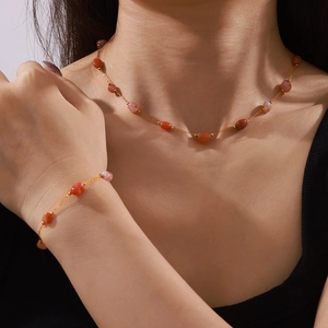 Elegant gold necklace and bracelet set featuring natural agate beads on a model