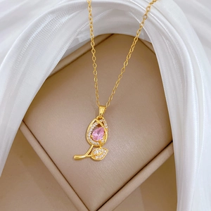 Close-up of pink tulip pendant with gold chain and zircon inlay on white silk
