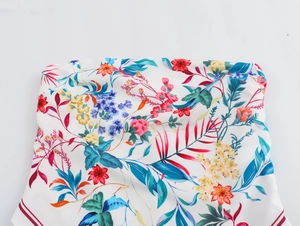 Detailed close-up of floral print top with red striped trim on soft chiffon fabric