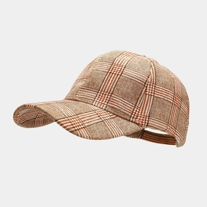 Detail view of adjustable strap and check pattern on brown cotton baseball cap
