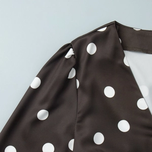 Détail des épaules bouffantes et pois blancs sur le tissu en mousseline marron foncé