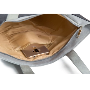 Detail of canvas tote bag interior showing the zipper pocket and functional storage space