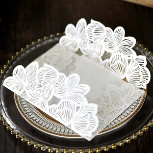 Detail of white laser-cut floral wedding invitation card with elegant gatefold design