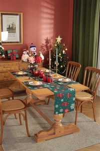 Detailed view of dark green Christmas table runner and mats with red festive ornaments