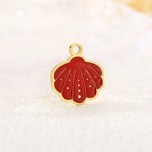 Detailed close-up of shell-shaped golden and red metal pendants for DIY jewelry making