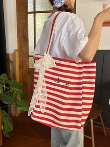 Striped canvas tote bag with black butterfly embroidery and large lace bow detail