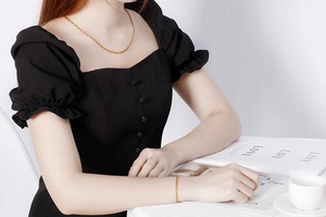 Close-up of elegant gold minimalist geometric necklace and bracelet set on a model