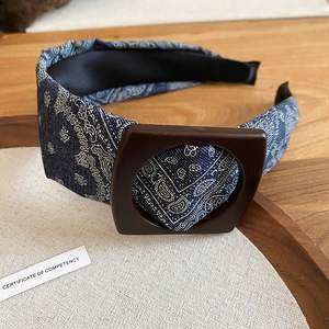 Close-up of blue paisley fabric headband with a vintage brown wooden buckle detail