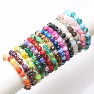 Assorted colorful glass and resin crystal beads stacked on a white display for DIY jewelry