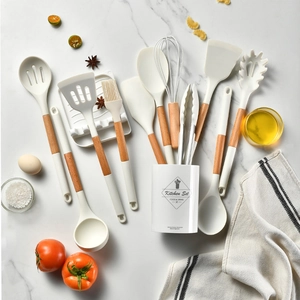 Detailed set of 11 white silicone cooking utensils with wooden handles on marble