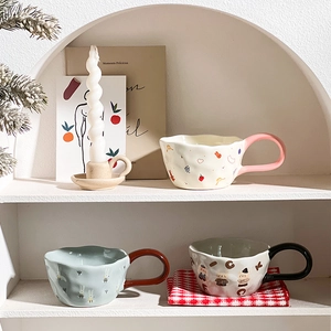 Cute ceramic bear and rabbit mugs with cream and blue colors on a rustic tablecloth