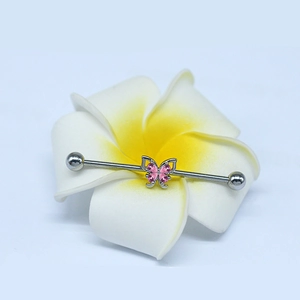 Silver industrial barbell with pink butterfly crystals placed on a flower