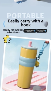 Detail of portable tumbler featuring a nylon handle, bear charm, and silicone sleeve