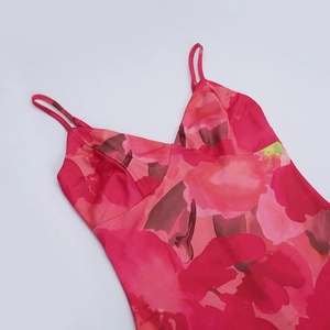 Gros plan sur le décolleté en V et les bretelles d'une robe d'été à fleurs roses