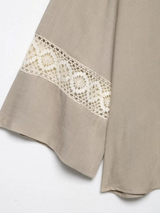 Close-up of khaki linen sleeve featuring exquisite white lace crochet embroidery details