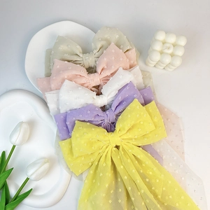 Flat lay of colorful chiffon polka dot bow hair clips with long elegant streamers