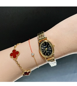 Close-up of a women's quartz watch featuring an oval black dial and golden metal strap