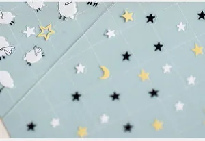 Macro shot of 5D thin nail art stickers featuring cute sheep and stars on a grid background