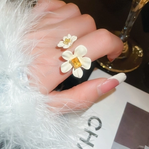 Close-up of gold plated flower petals open ring featuring yellow cubic zirconia stones