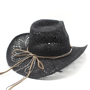 Close-up of black hollow-out straw cowboy hat with woven cord and bow tie detail